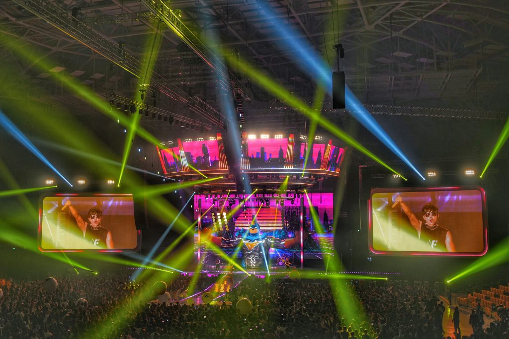 Escenario de concierto con diseño visual creativo, pantallas LED geométricas y sistema de iluminación escénica frente al público