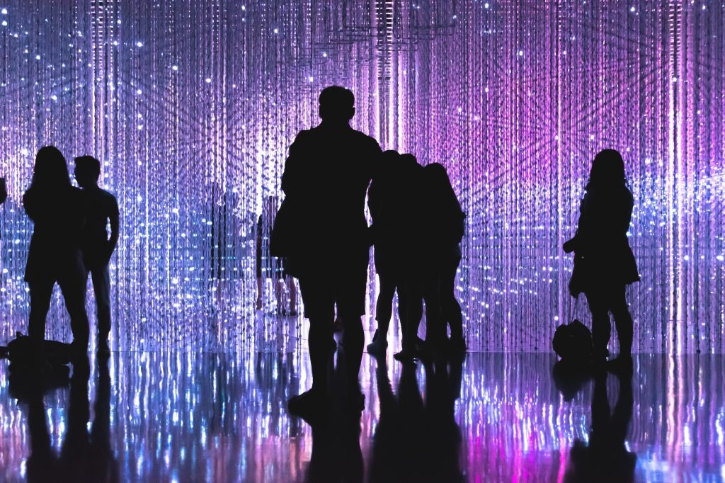 Asistentes entrando en espacio iluminado con efectos visuales