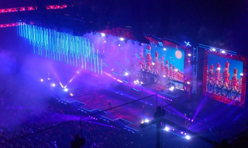 Gran escenario de concierto con pantallas LED gigantes, iluminación de espectáculo y público en directo viviendo la experiencia visual del show